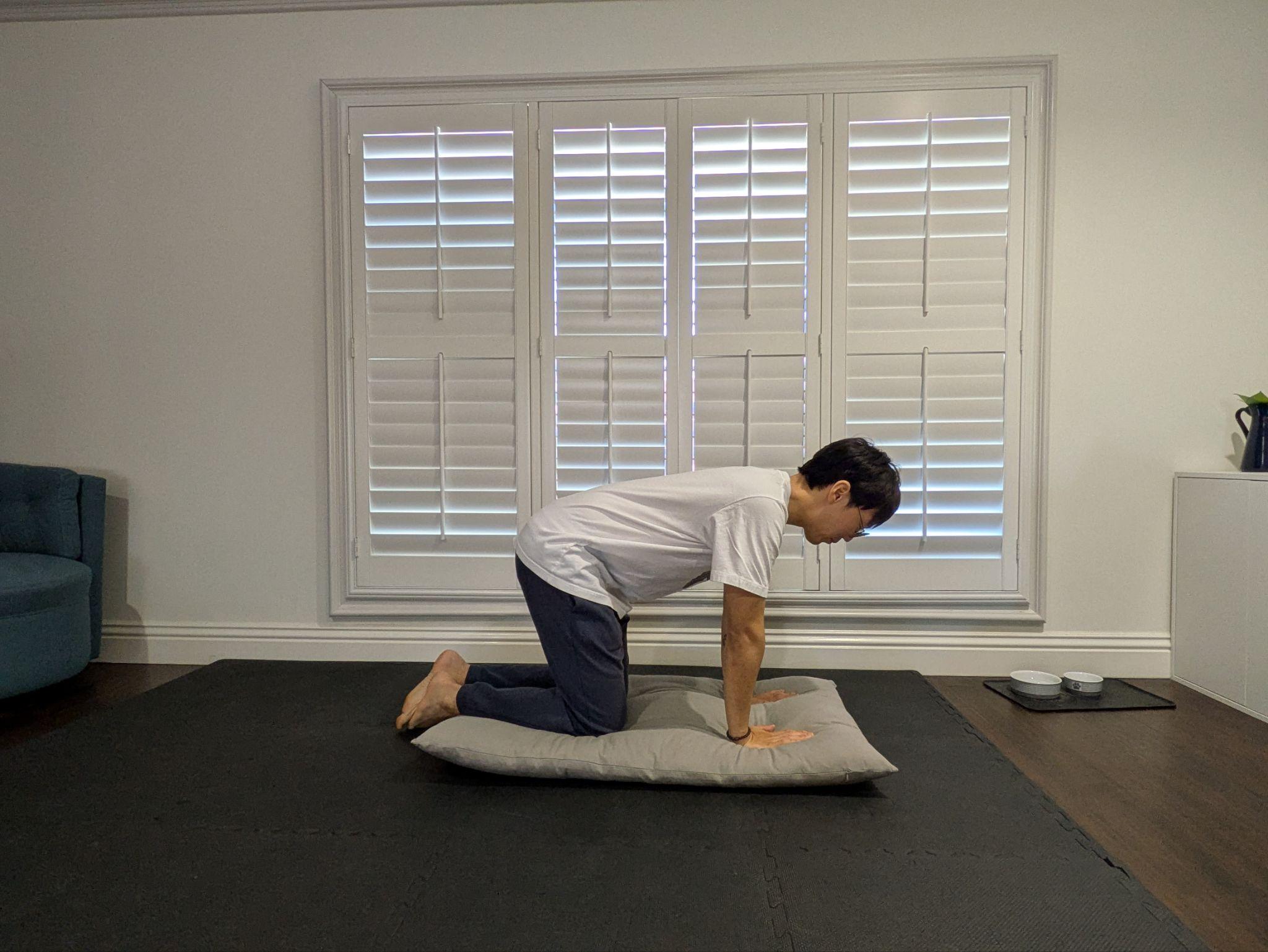 Kneeling with hands placed on the cushion, feet crossed